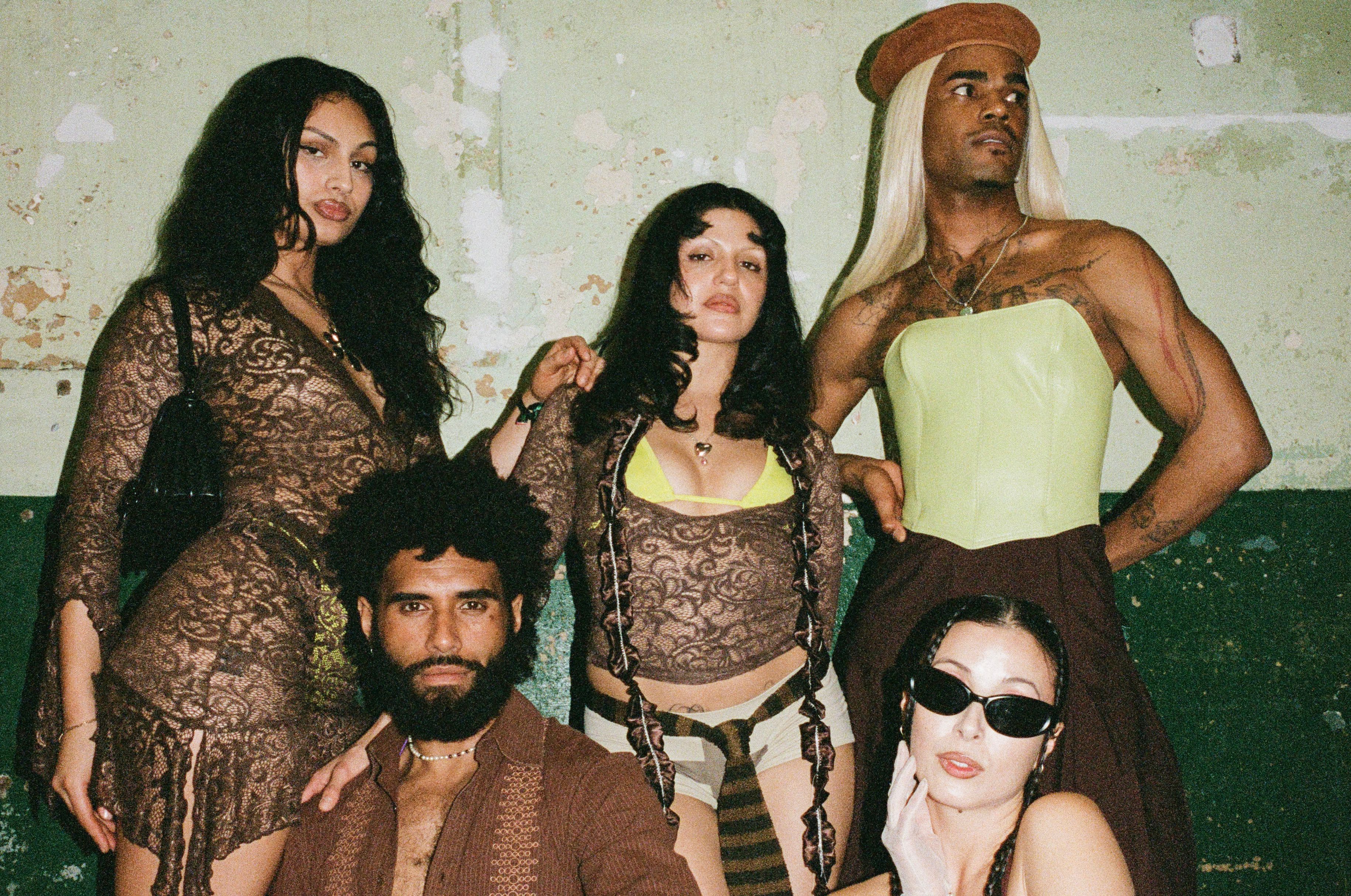 Five people, scantily clad, fiercly pose