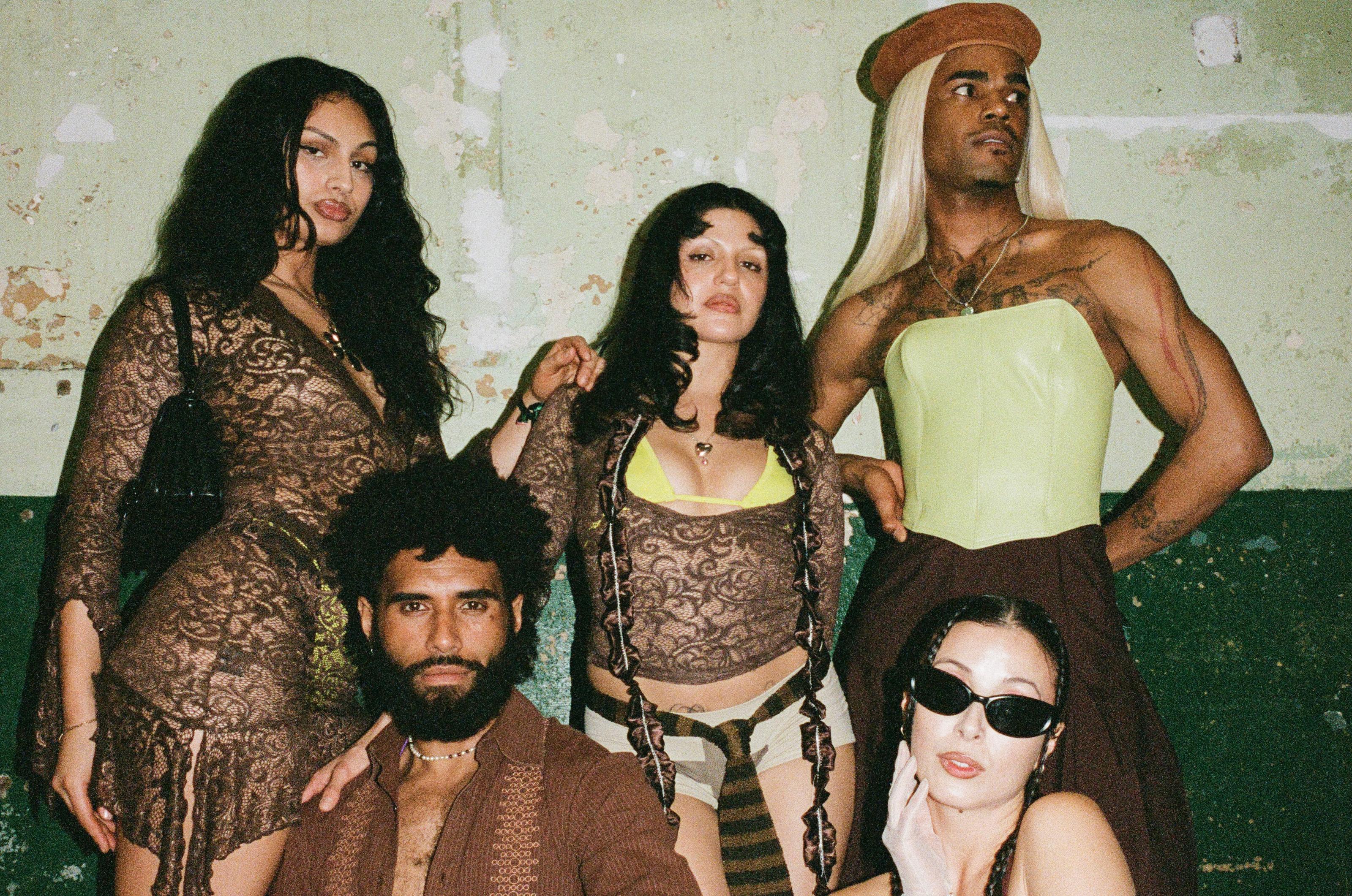 Five people, scantily clad, fiercly pose