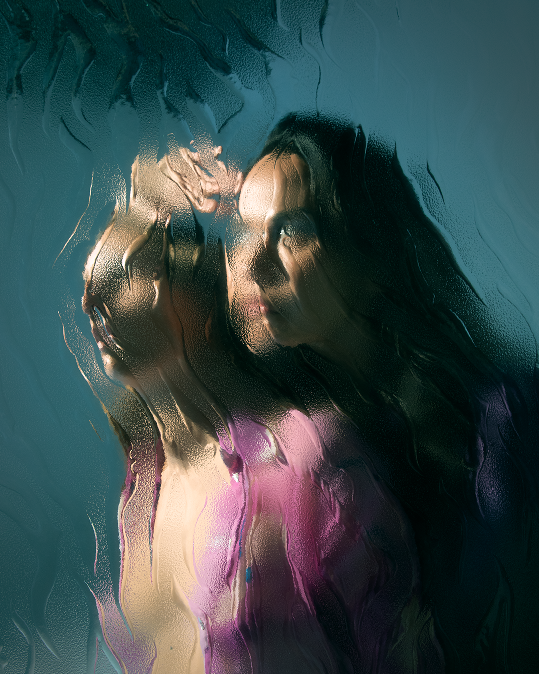 Two figures seen through a textured glass, partially obstructed.