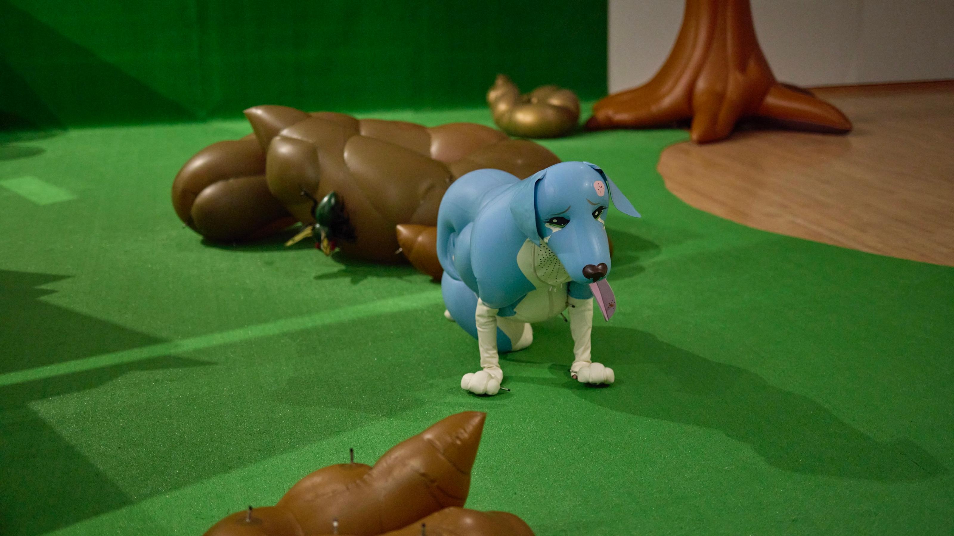 A blue and white inflatable dog stands on all fours, wearing a sad, concerned expression, with tears rolling down its face.