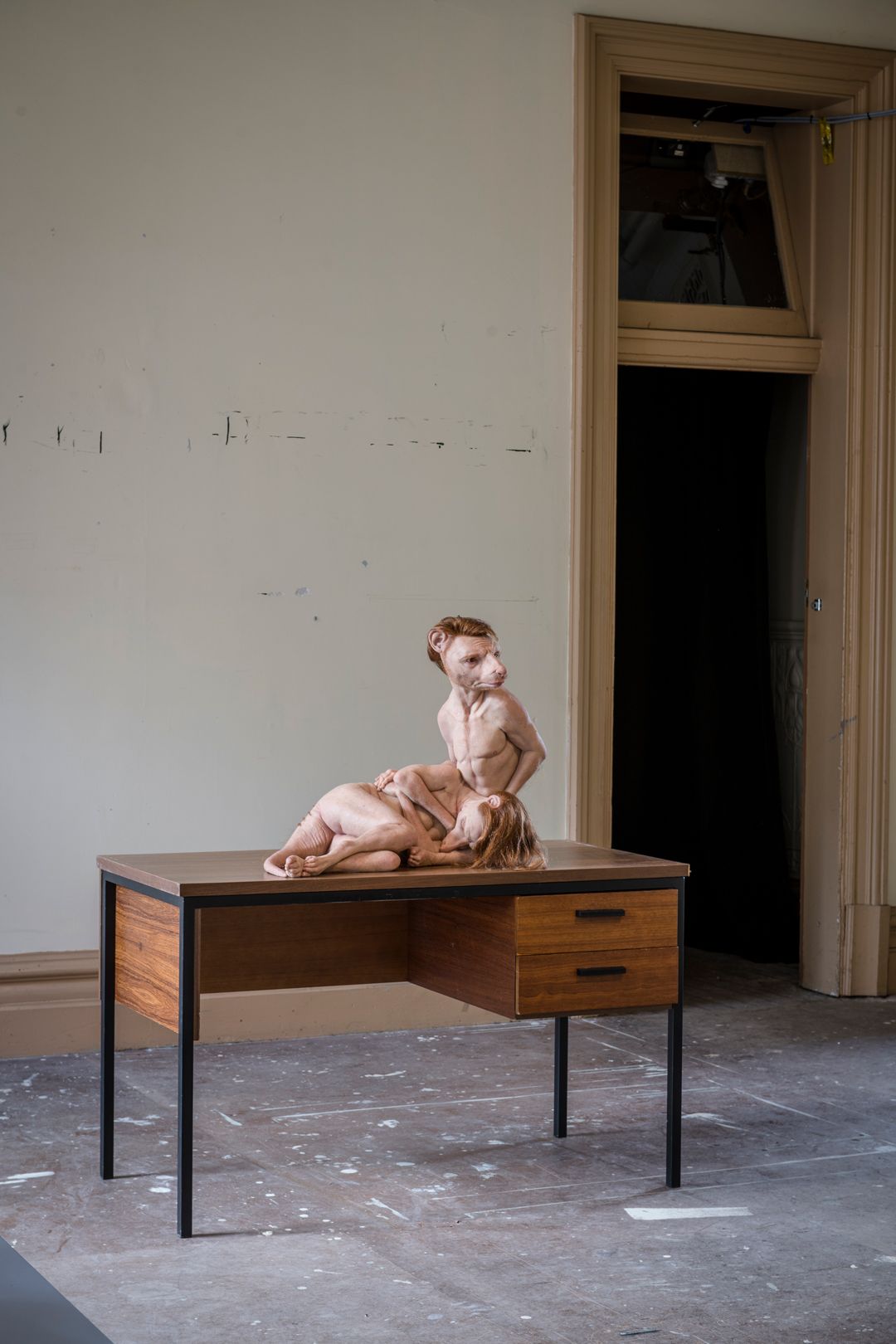 Installation view of Patricia Piccinini's work While She Sleeps of two thylacines displayed on a discarded desk from the station's rooms. 