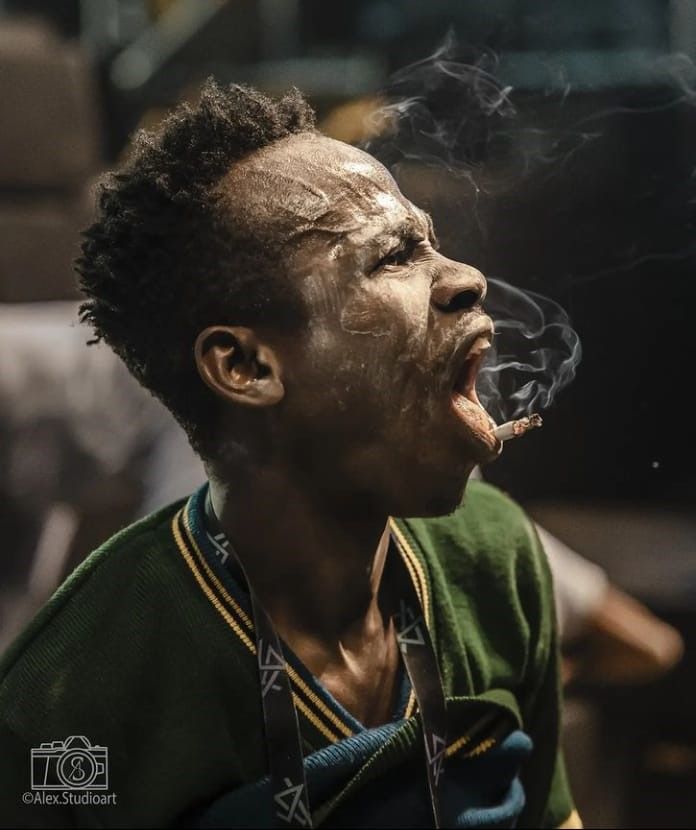 A side close-up of a performer exhaling smoke during an intense moment.