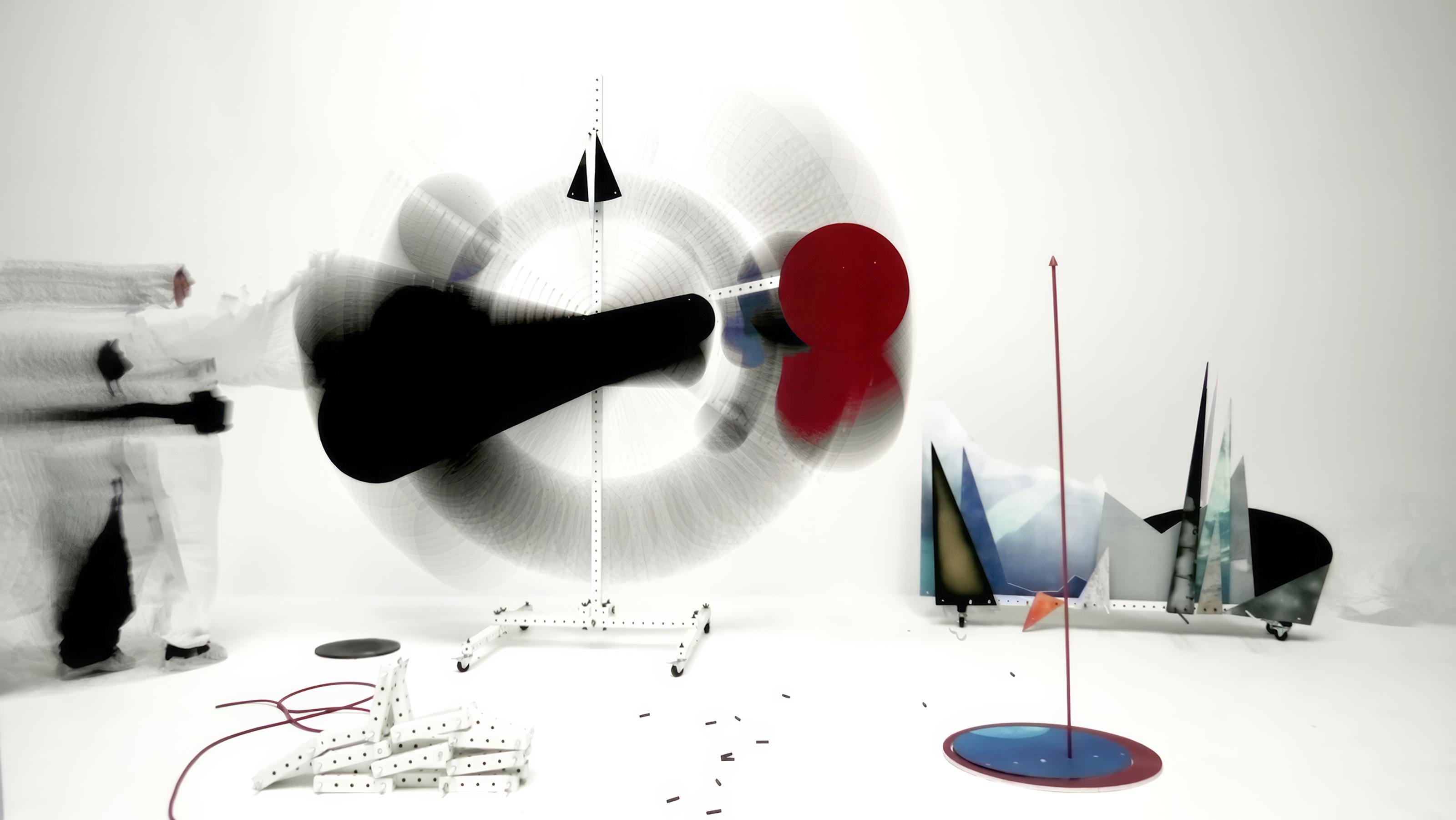 A large circle is created by something spinning in motion, being pushed around by a person in a hazmat suit who is also in motion.