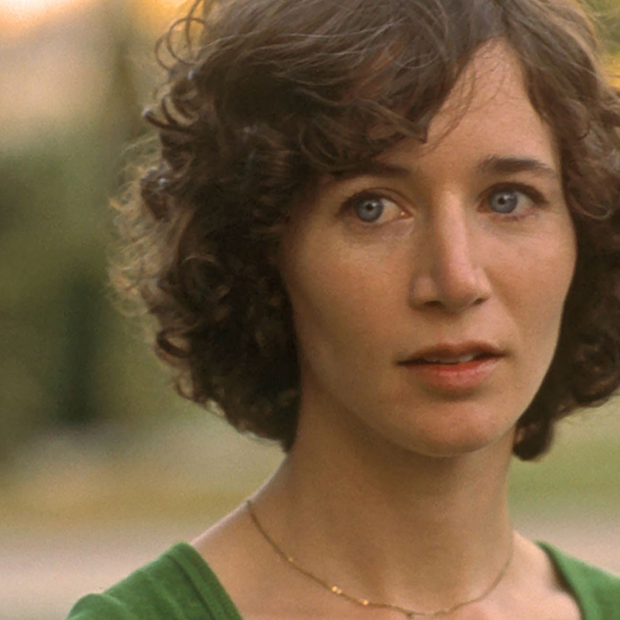 A still from Me and You Everyone We Know (2005). A person with short, curly brown hair and a neutral, slightly concerned expression looks ahead.