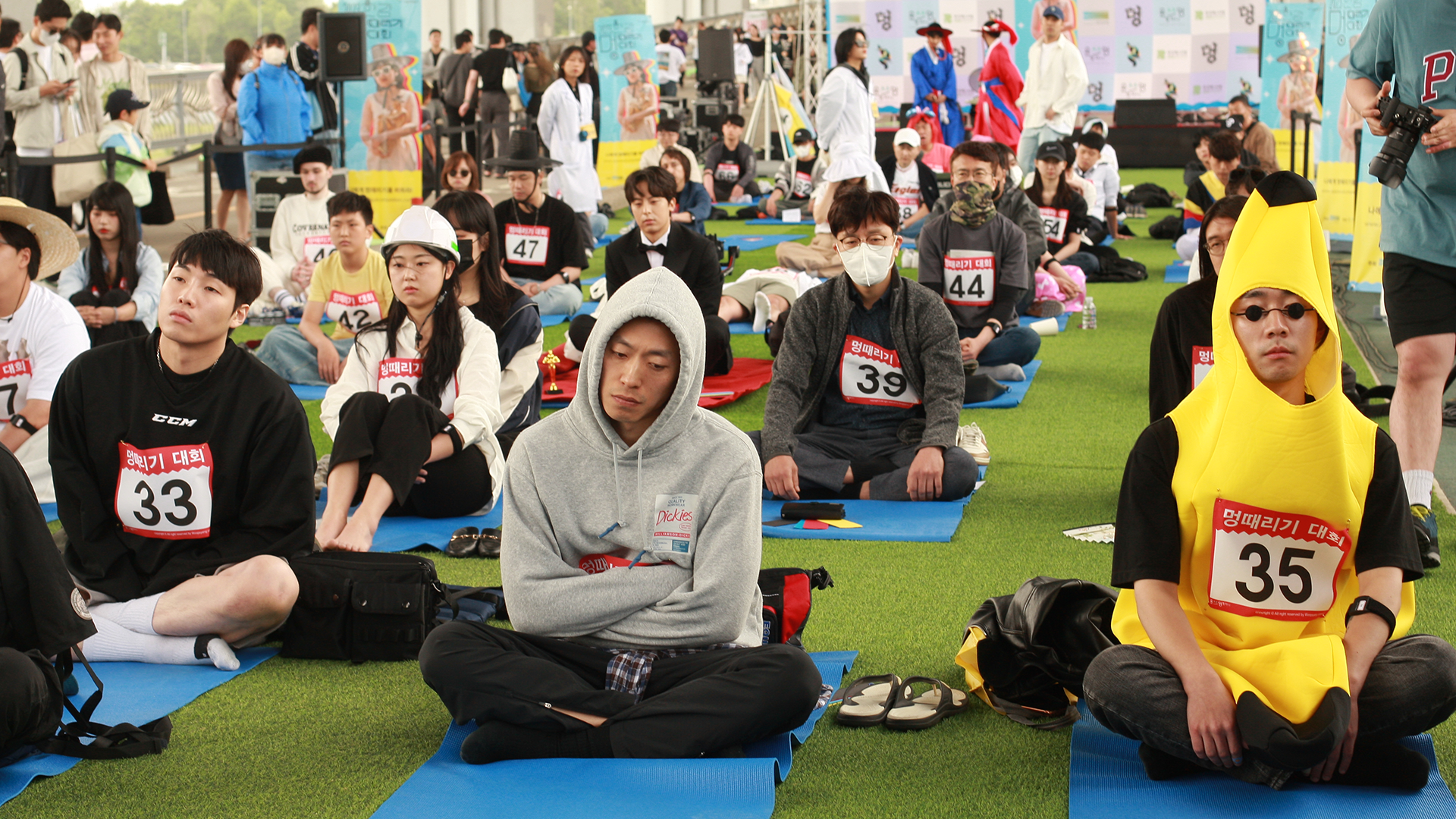 Dozens of people seated on yoga mats 'zoning out'