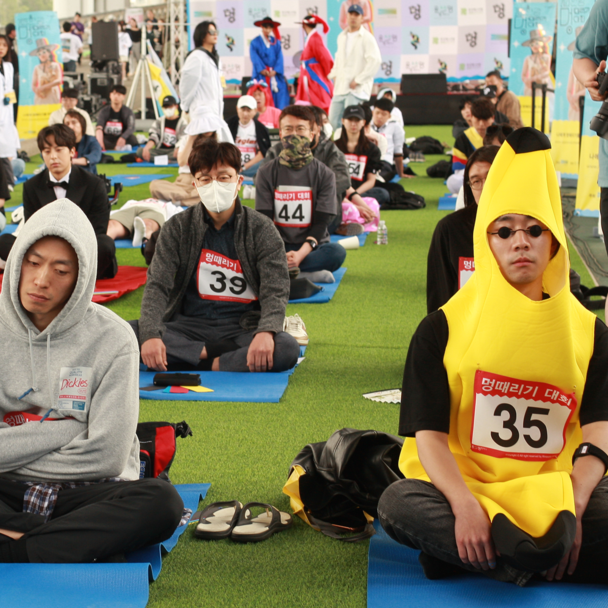 Dozens of people seated on yoga mats 'zoning out'